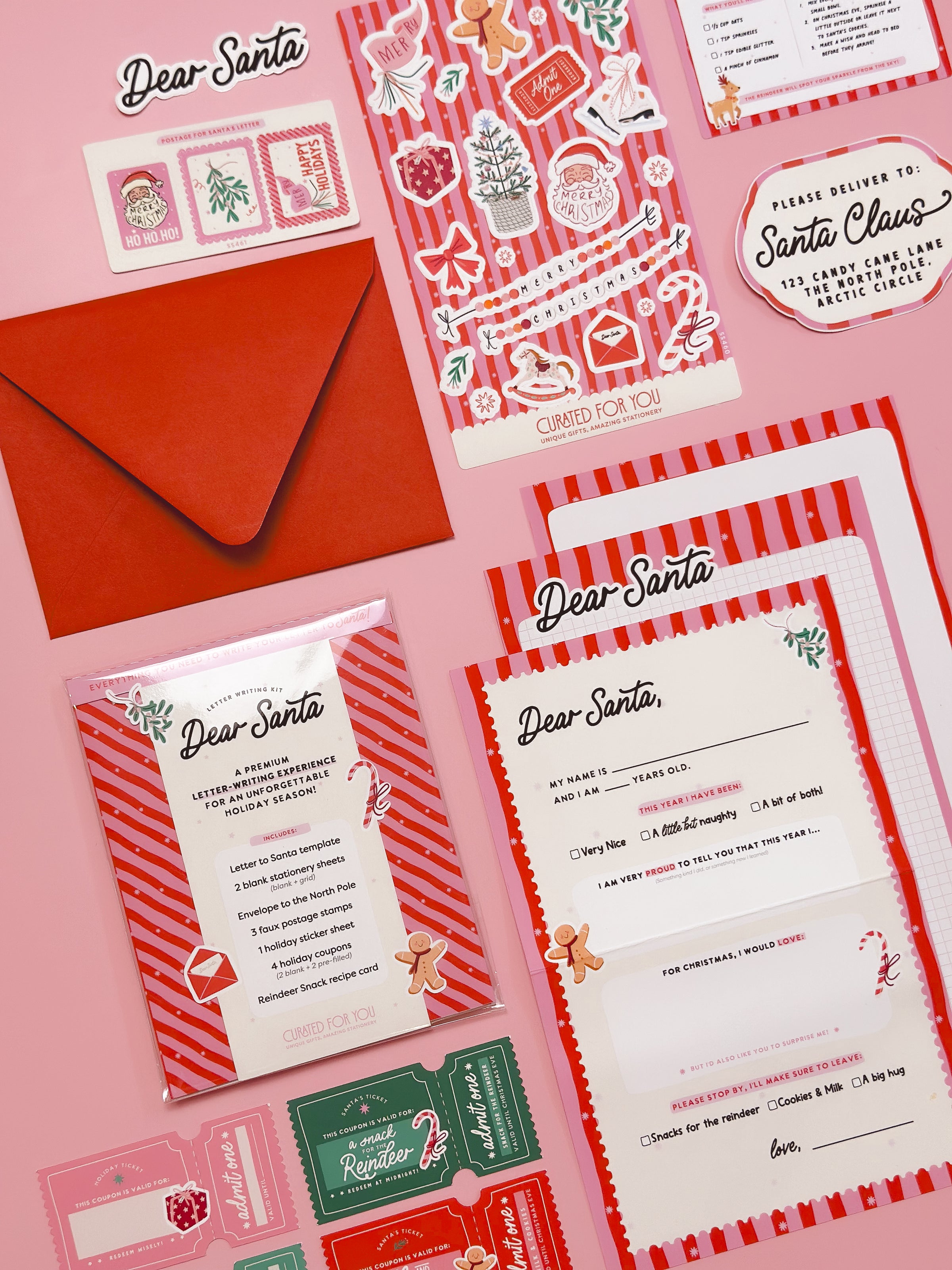 Flat lay of Letter to Santa Template kit including sticker sheet, coupons, and reindeer snack recipe card, on a pink background and festive red and pink striped stationery