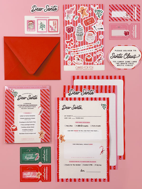 Flat lay of a Letter to Santa Kit for kids featuring red and pink Christmas stationery, envelope to the North Pole, decorative postage stamps, holiday stickers, activity coupons, and a reindeer snack recipe card. A festive Christmas activity set made in Canada, perfect for holiday traditions, Elf on the Shelf ideas, and family keepsakes.